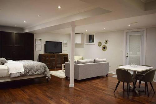 多伦多Home Away From Home - Basement Studio Apartment的一间卧室配有一张床、一张沙发和一张桌子
