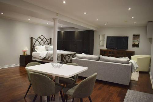 多伦多Home Away From Home - Basement Studio Apartment的客厅配有沙发、桌子和床。