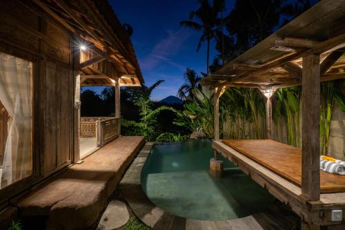 德格拉朗Umah Capung Sebatu Villas的户外庭院设有长凳和小型游泳池。