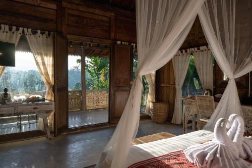 德格拉朗Umah Capung Sebatu Villas的卧室配有一张床、一张书桌和窗户。