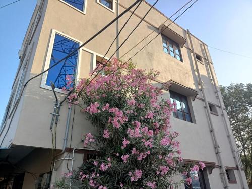 蒂鲁帕蒂ADVIK HOMESTAYS的前面有粉红色花的建筑