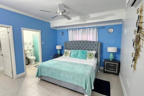 卢西Snooze at Oceanpointe的蓝色卧室配有床和吊扇