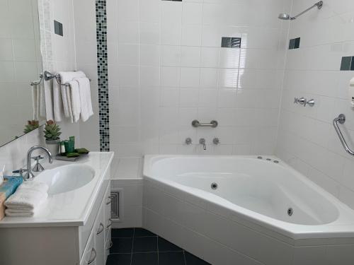 蚬壳港贝壳港鹈鹕休闲公寓的白色的浴室设有浴缸和水槽。
