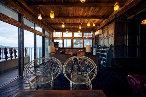 鹿儿岛Guest House CARAPAN的一间设有三把椅子和桌子的房间,窗户