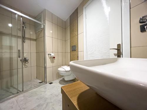 伊兹密尔Helen Inn的一间带水槽、淋浴和卫生间的浴室