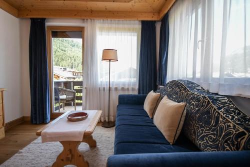 塞尔瓦迪加尔代纳山谷蒂罗尔酒店的客厅配有蓝色的沙发和桌子