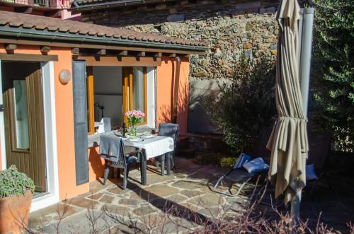 隆科索普拉阿斯科纳Rustico al Sole - Just renewed 1bedroom home in Ronco sopra Ascona的庭院配有遮阳伞、桌椅和遮阳伞。