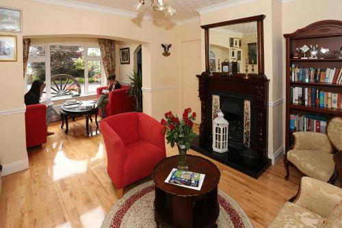 阿德莫尔新城农场酒店的客厅设有红色椅子和壁炉
