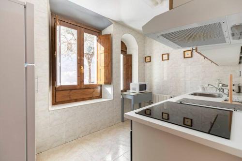 坎弗兰克埃斯塔西翁Espectacular apartamento reformado en edificio histórico, con WIFI的白色的厨房设有水槽和窗户