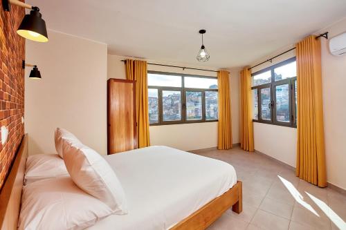 塔那那利佛La Pergola - Appartement Hôtel的一间卧室设有一张床和两个窗户。
