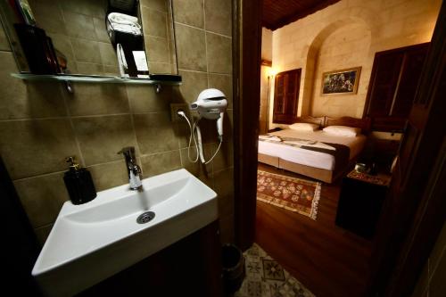 尚勒乌尔法Kaliruha Boutique Hotel的一间带水槽的浴室和一间带一张床的卧室
