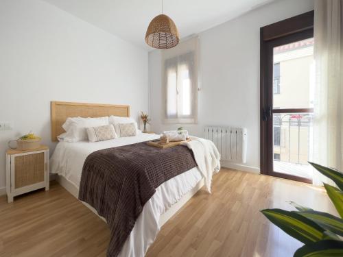普拉森西亚Apartamentos Turísticos Con Alma的白色卧室设有一张大床,铺有木地板