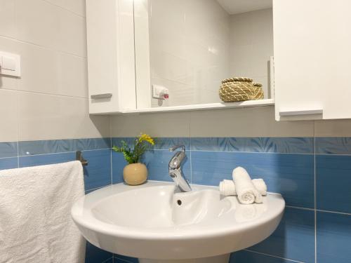 普拉森西亚Apartamentos Turísticos Con Alma的浴室设有蓝色瓷砖,配有白色水槽。