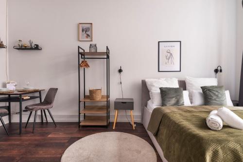柏林Central Apartment in Heart of Berlin的卧室配有1张床、1张桌子和1把椅子