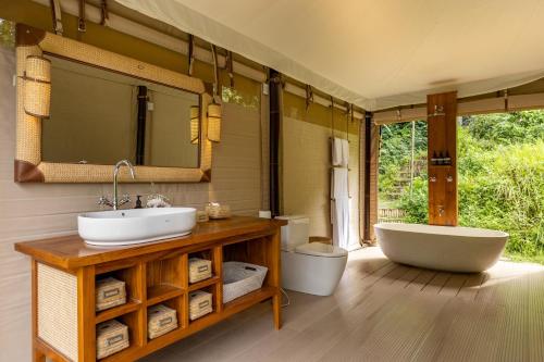塔巴南Nadi Nature Resort - Adults Only的浴室设有2个水槽、浴缸和镜子