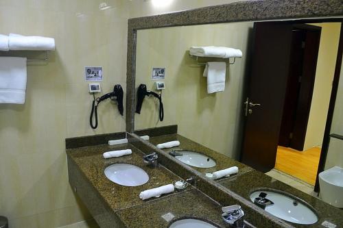 多哈Palm Inn Hotel Doha的一间酒店客房内带三个水槽的浴室