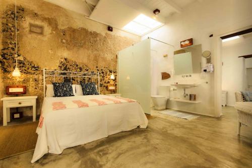 蓬塔穆赫雷斯萨利纳斯公寓的一间卧室配有一张床,浴室设有水槽