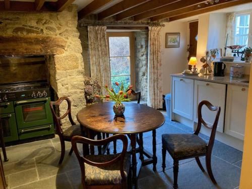 巴维特雷西Little Reeds的厨房配有桌子和绿色炉灶。
