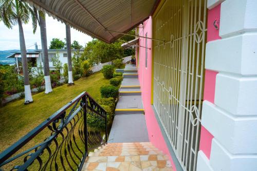 蒙特哥贝Three Palm Villa的粉红色的房子,有楼梯通往房子