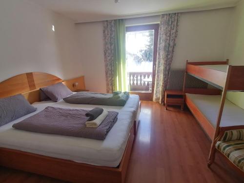 皮恩山口附近施皮塔尔欧博温格尔霍夫公寓式酒店的一间卧室设有两张床,窗户设有阳台