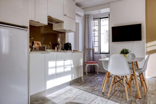 法鲁Palacete da Baixa by MY CHOICE的厨房配有白色橱柜和桌椅