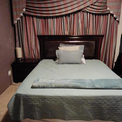 内尔斯普雷特TINDLOVU GUESTHOUSE的一间卧室配有一张带条纹墙的床