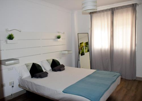 厄尔梅达诺Blue waves - free parking的一间卧室配有一张白色的床和蓝色的毯子