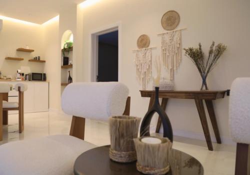 八田Quiet House villa的客厅配有白色的椅子和桌子