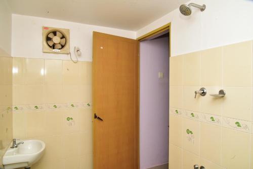 TellicherryBella Apartments的一间带水槽和木门的浴室