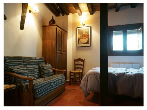 埃尔瓦维克多查莫罗阿科乡村公寓酒店的一间卧室配有一张床、一张沙发和一把椅子