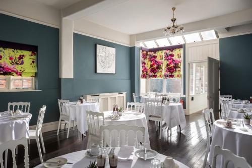 利奇菲尔德St Johns House Lichfield的一间设有白色桌椅的用餐室