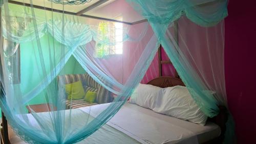 迪亚尼海滩Armaan Guest House的一间卧室配有带蚊帐的天蓬床。