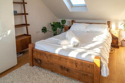 约克Stylish 4 Bedroom Home York - Garden - Parking的一间卧室配有一张带白色床单的床和一扇窗户。