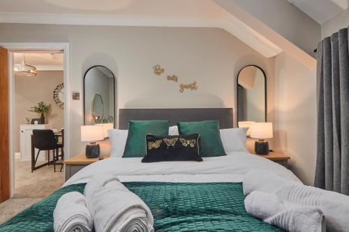 哈罗盖特The Swan Apartment - Free parking的一间卧室配有一张带绿色枕头的大床