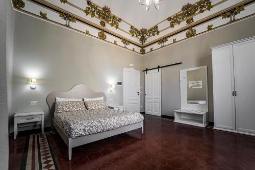 锡拉库扎Gli specchi di Archimede的一间卧室设有床铺和鲜花天花板