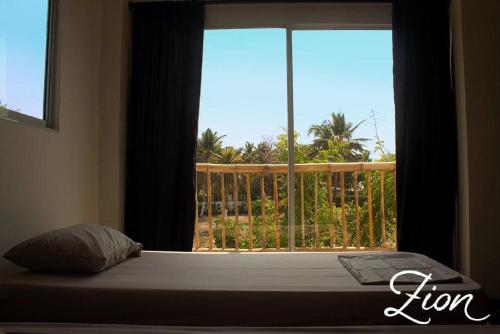 卡塔赫纳Zion Beach House的一张带窗户的床铺,享有阳台的景色