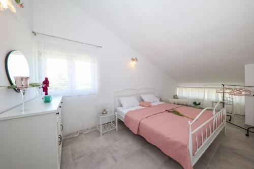 扎达尔Apartment Fiorino的白色卧室配有一张带粉色毯子的床