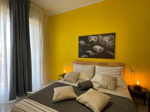 沃拉B&B D'Aponte Home的一间卧室设有一张黄色墙壁的大床