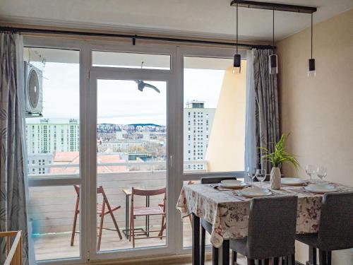 佩奇Pajger Apartman Egyetemváros的一间带桌子的用餐室和一个阳台