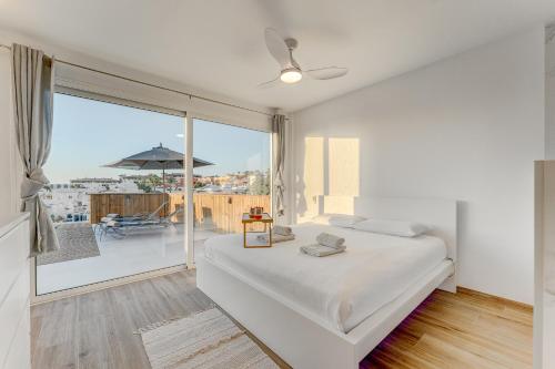 帕莱索海滩Calma Paraiso的一间卧室设有一张床和一个大窗户
