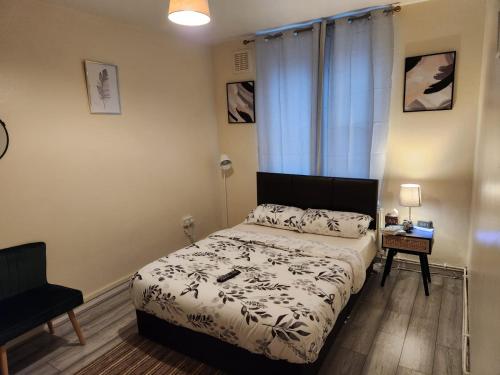 伦敦2-bedroom flat in Cutty-Sark, Greenwich !的一间小卧室,配有一张床和一把椅子