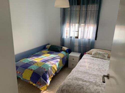 拜纳Apartamento Al Andalus的一间卧室设有两张单人床和一个窗户。