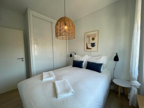 里斯本The Swallows Nest的卧室配有一张带吊灯的大型白色床。
