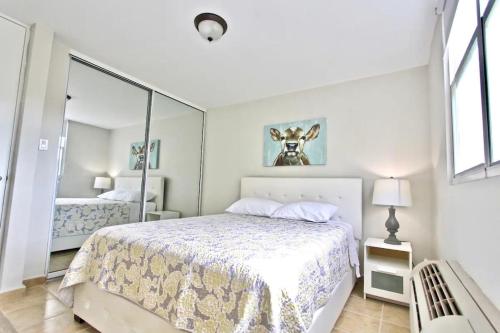 法哈多Ocean & Marina Views 3 Bedroom 2 Bathroom Luxury Condo的白色卧室配有床和镜子
