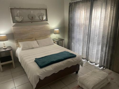 鲸湾港Anas Inn的一间卧室设有一张大床和两个窗户。