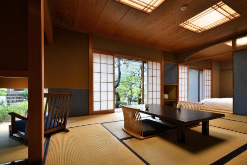 伊豆Oni no Sumika的客房设有桌子、床和窗户。