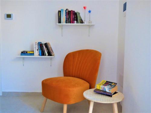 那不勒斯Napoletando b&b的橙色椅子和带书籍的边桌