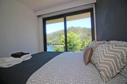 吉尔斯Apartamento Lobo - Casas Barca do Rio - Geres的一间卧室设有一张大床和大窗户