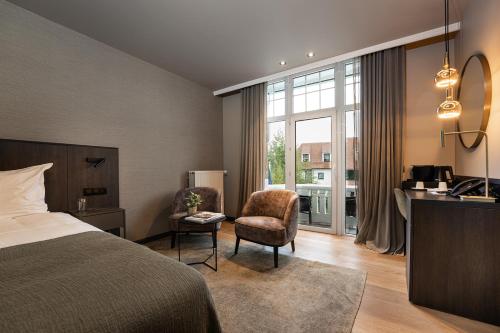 克诺克－海斯特布里塔尼亚酒店的酒店客房,配有一张床、一张桌子和椅子