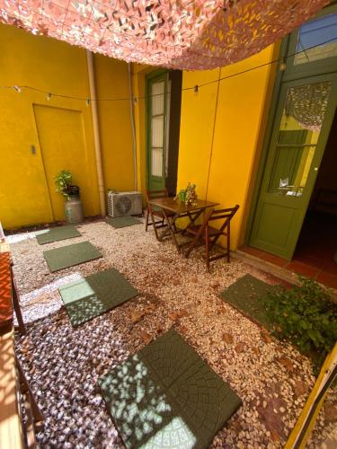科洛尼亚-德尔萨克拉门托Casa Calma的一个带桌子的庭院和一座黄色的建筑